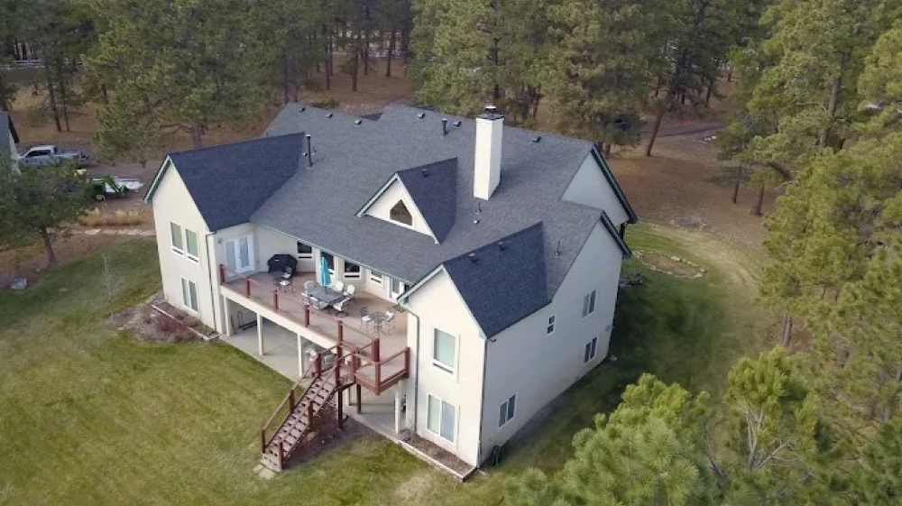 An aerial view of a completed Gen 3 Roofing replacement in the Colorado pines