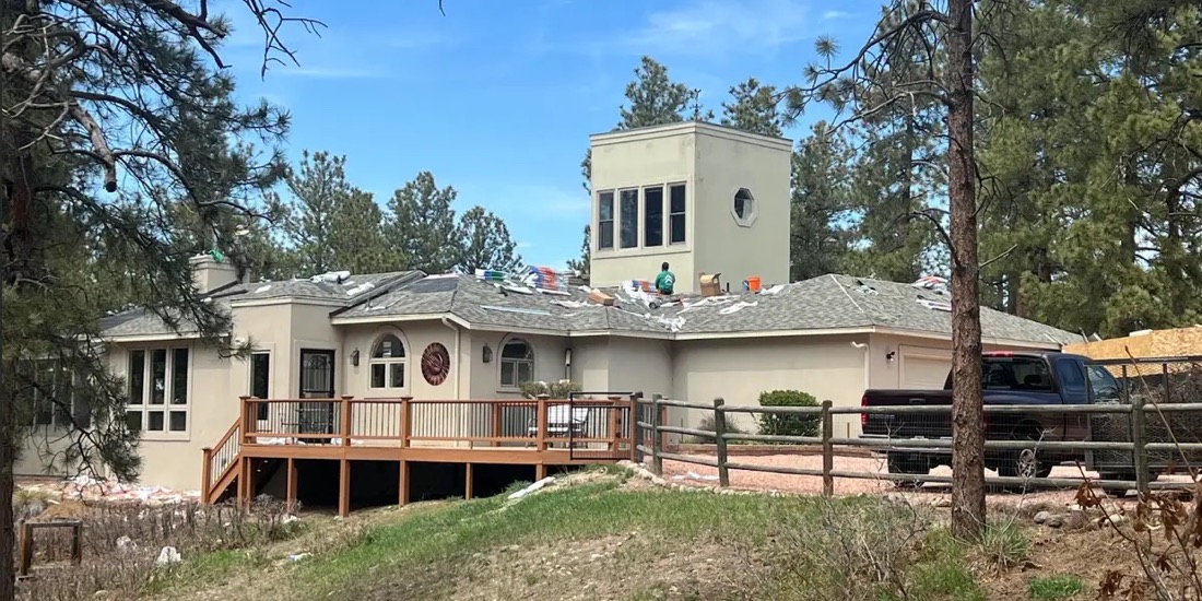A Gen 3 Roofing crew replacing a roof on a house in the Colorado pines