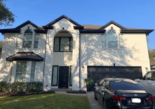 The same Houston house after Liberty Painting repainted it white with black trim